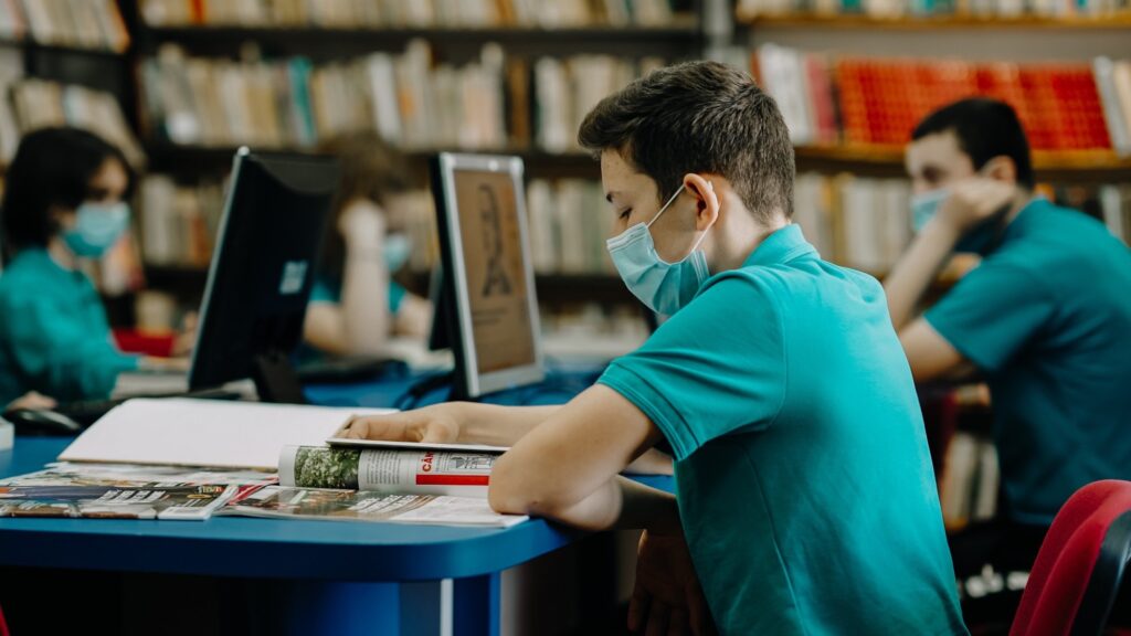 Encourage A Healthy Lifestyle. Student studying with a mask on.